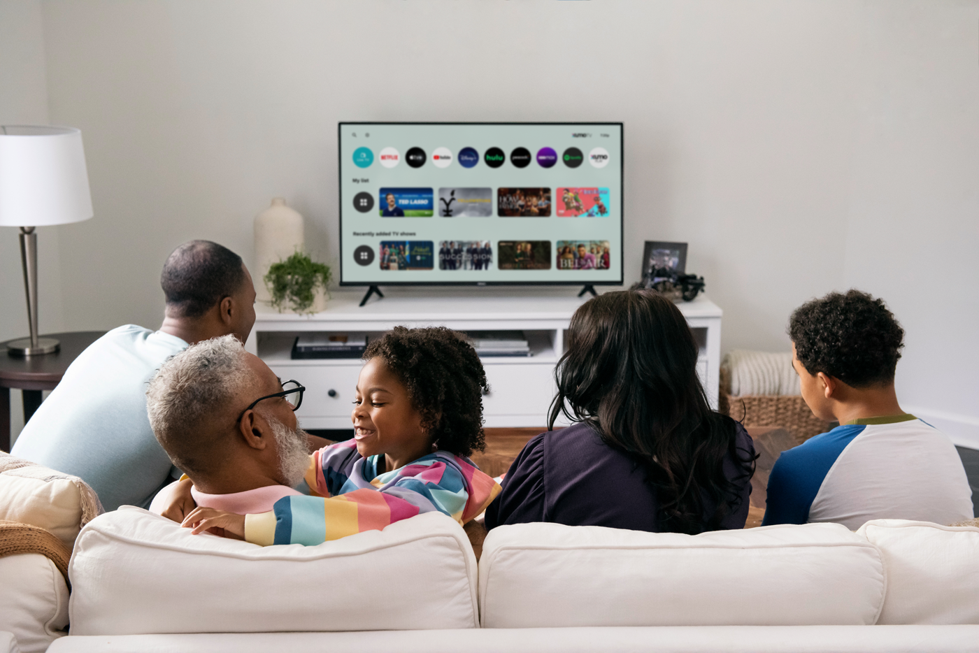 A family sitting on the couch watching a Xumo TV