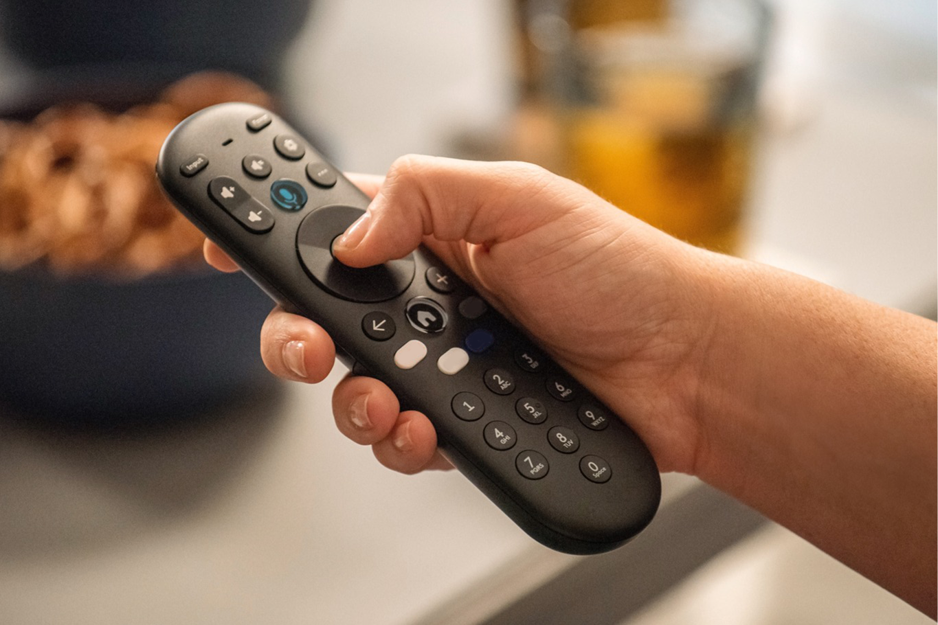 A person holding a remote for a Xumo TV