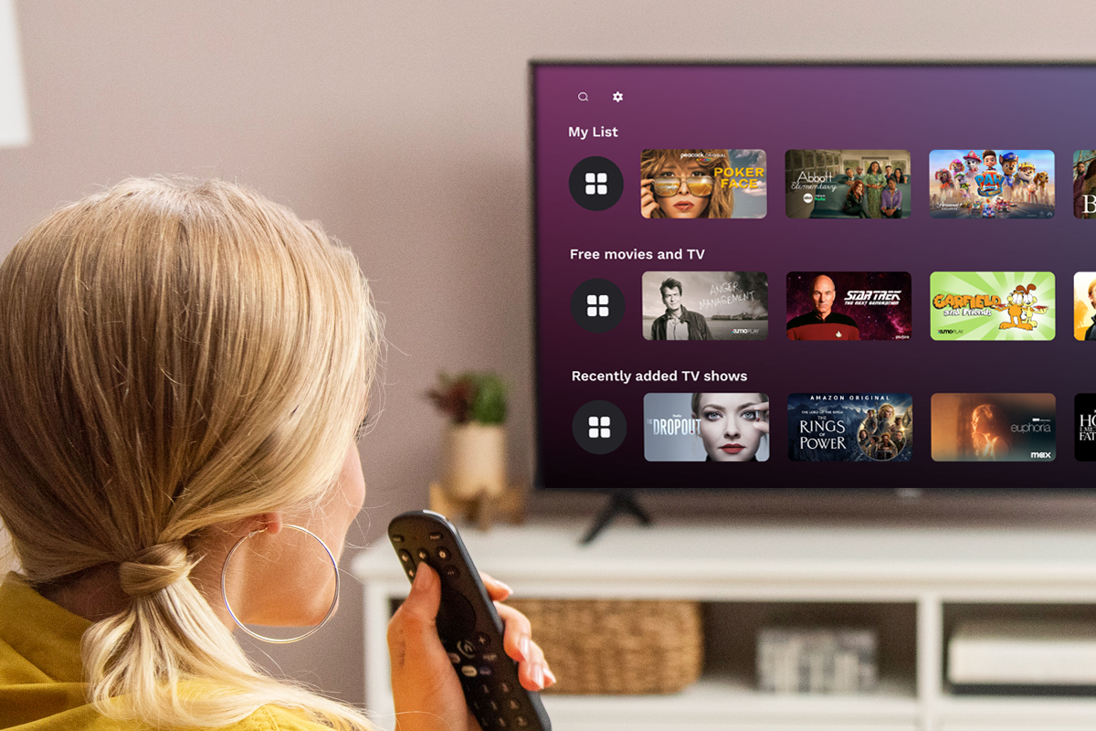 A woman speaking into a voice remote while viewing the My List feature on a Xumo TV